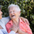 elderly woman laughing with her support caregiver. concept of mental health, retirement and family.